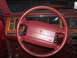 1993 Lincoln Town Car - The interior of a 1990s Lincoln Town Car, a red steering wheel and wood-grain dashboard accents.