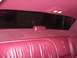 1993 Lincoln Town Car - The plush red interior of a 1993 Lincoln Town Car, its rear seating area and window.