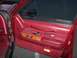 1993 Lincoln Town Car - Close-up of a car's interior door panel, showing red upholstery and wood accents.