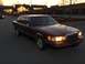 1993 Lincoln Town Car - A maroon 1993 Lincoln Town Car is parked in a lot as the sun sets, with another vehicle visible in the distance.