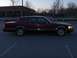 1993 Lincoln Town Car - A maroon sedan is parked in a lot at dusk, showing its side profile and chrome accents.