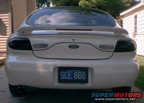 Rear view of a white 1997 Ford Taurus with a spoiler and Michigan license plate SCE 860