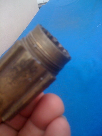 Brass fitting with threaded end held by fingers