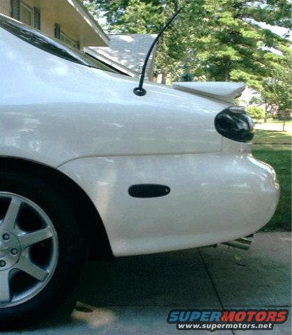 White sedan rear quarter panel with spoiler and antenna