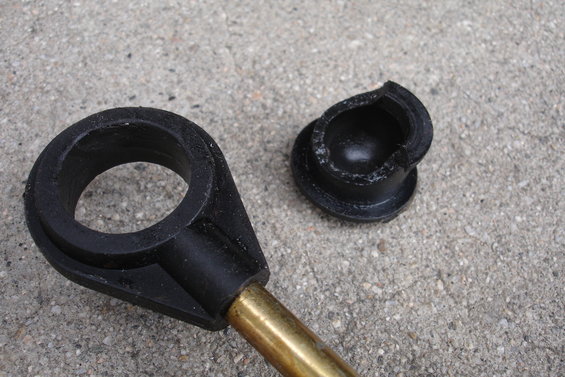 Black plastic rod shifter component and a broken cap on concrete