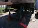 1989 Ford Bronco - The underside of a vehicle is supported by jack stands, revealing suspension and axle components during a repair or modification.
