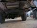 1989 Ford Bronco - The underside of a vehicle is visible, with focus on the drivetrain and rear axle assembly.