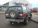 1989 Ford Bronco - This 1989 Ford Bronco is seen from the rear, a spare tire mounted on the tailgate and a red pickup truck in the background.