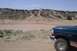 1995 Ford Bronco - A 1995 Ford Bronco is parked in a dry, hilly terrain with a clear blue sky overhead.