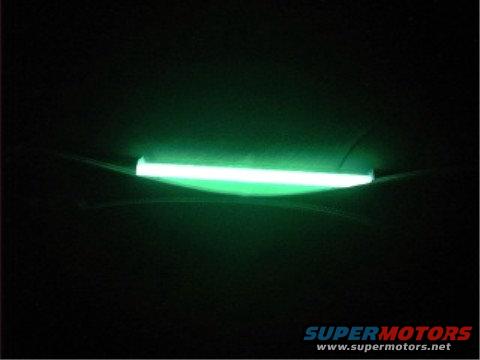 Green neon light strip mounted underneath a dark vehicle