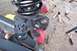 1989 Ford Bronco - A close-up view of a vehicle's suspension components, including a coil spring and mounting bracket, with tools scattered around.