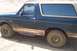 1995 Ford Bronco - Mud-covered 1995 Ford Bronco parked on a dirt road.