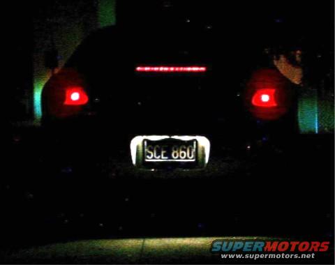 Rear view of a dark sedan with red taillights and license plate SCE 860