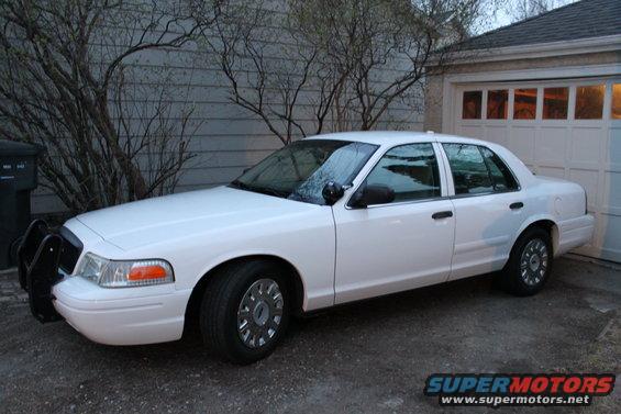 White 2003 Ford Crown Victoria parked in driveway, front push bumper visible