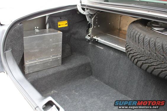 Trunk interior showing a metal storage box on the left and a spare tire on the right