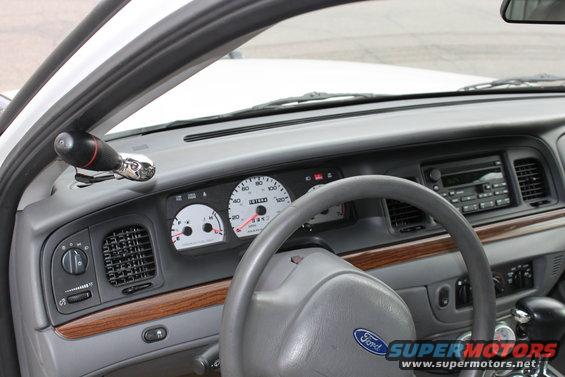 Dashboard of a car with a steering wheel, radio, and gauges. The Ford logo is visible on the steering wheel