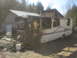 1998 GMC Sierra 3500 - An RV is parked next to a building in a wooded area.