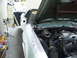1973 Ford Ranchero - The engine bay and front fender of a car are visible, with the hood open, in what appears to be a workshop.