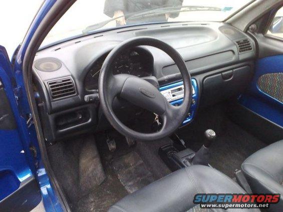 Interior shot of a blue car, showing the dashboard, steering wheel, and seats