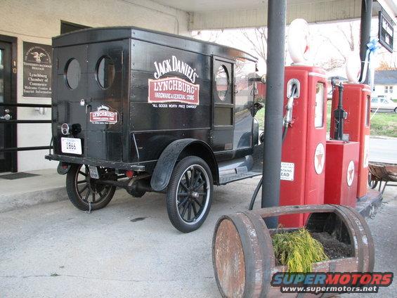 Black delivery truck with Jack Daniel's Lynchburg signage parked next to red gas pumps