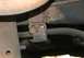 1976 Ford Ranchero - Underside view of a rusted suspension bracket and bar, likely from an older vehicle.
