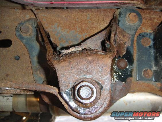 Heavily rusted vehicle frame bracket with a large bolt