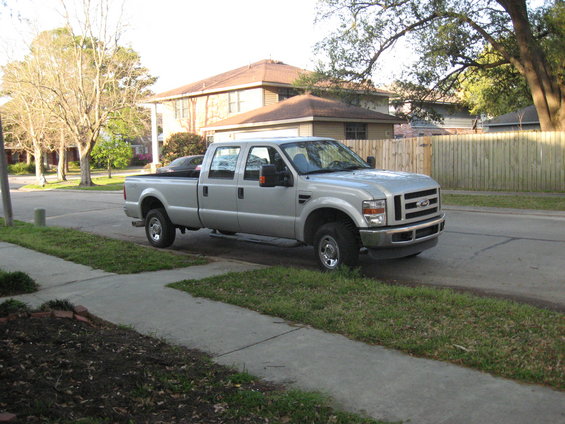 Silver 2008 Ford F-250 Super Duty pickup truck parked on a residential street, viewed from the front 3/4 angle