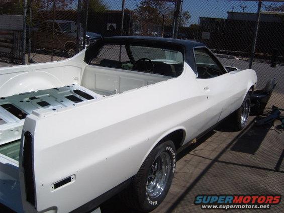 White 1972 Ford Ranchero with black vinyl top, undergoing restoration. Bed is empty, interior visible