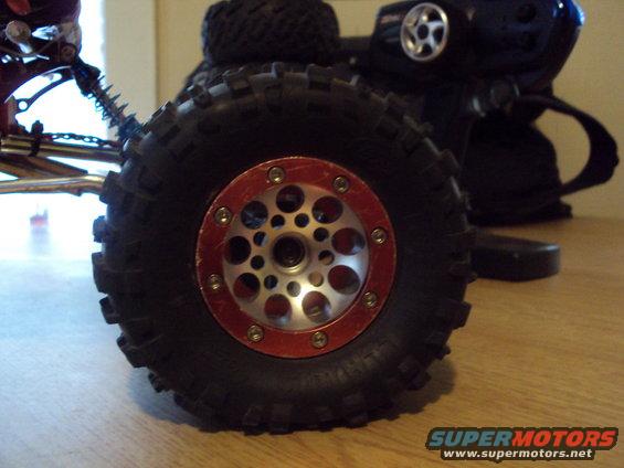 Close-up of a remote control car wheel with red rim and silver spokes