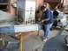 2000 Dodge 1500 - Man uses an angle grinder on a metal beam in an industrial setting with large machinery visible.