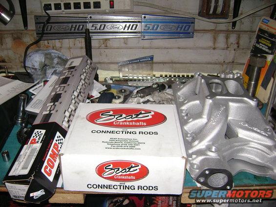 Silver aluminum intake manifold and boxes of Scat connecting rods on a workbench