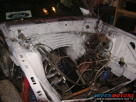 Ford engine bay with exposed wiring and engine components