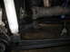 1987 Ford Bronco - Undercarriage view of a vehicle's suspension and drivetrain components, possibly undergoing maintenance.