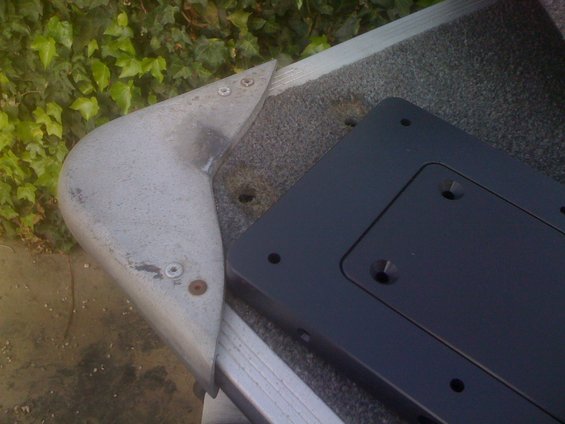 Aluminum boat corner bracket with carpeted surface and black mounting plate
