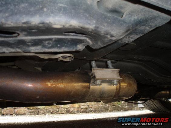 Exhaust pipe with a U-bolt clamp underneath a vehicle