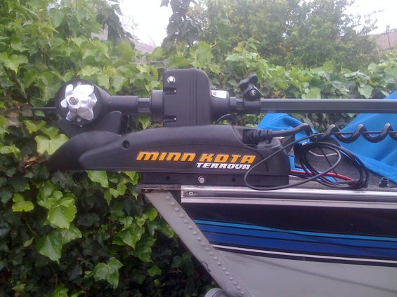 Minn Kota Terrova trolling motor mounted on a boat, with green foliage in the background