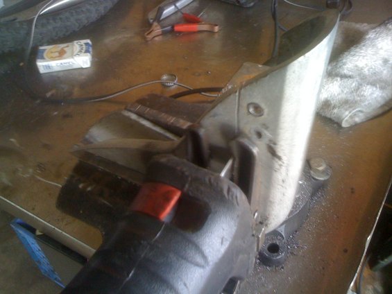 Metal part being cut in a vise with a cigarette pack nearby