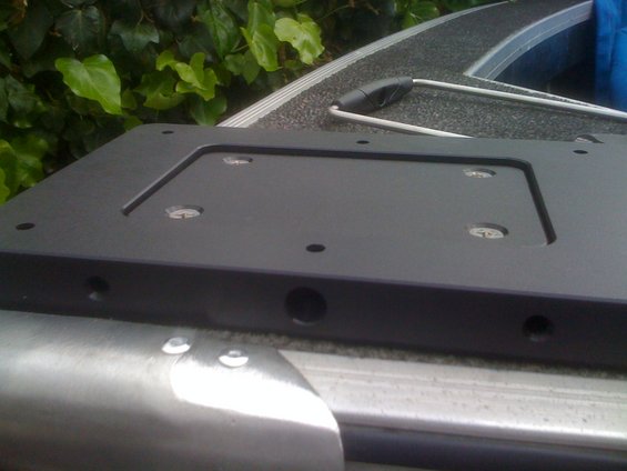 Black plastic mount with screw holes on a boat deck