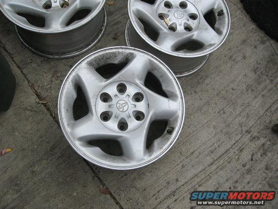 Four aluminum alloy wheels with Toyota logos on concrete
