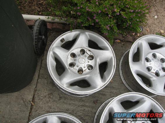 Several silver alloy wheels with a five-spoke design and a Toyota logo in the center