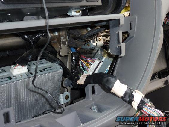 Vehicle interior wiring harness with exposed wires and connectors, gray dashboard trim