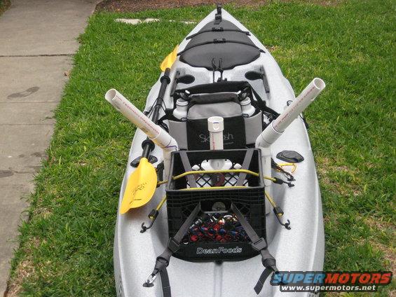 Kayak rigged with PVC rod holders and a milk crate for gear. Yellow paddles are attached