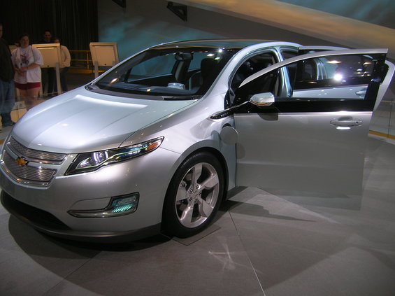 Silver Chevrolet Volt with front doors open, parked indoors