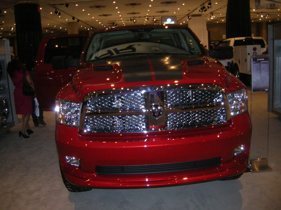 Front view of a red Dodge Ram truck with a black stripe on the hood