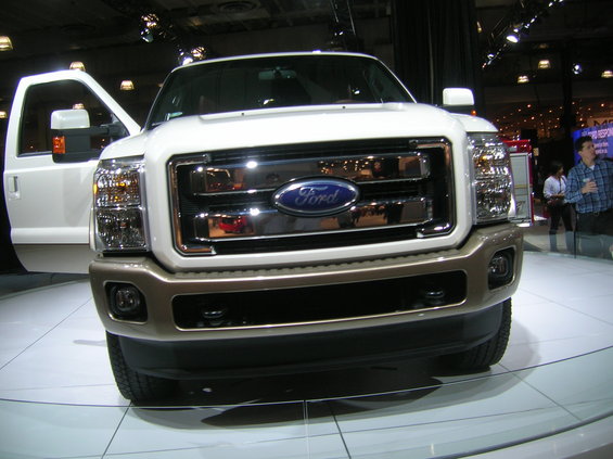 Front view of a white Ford F-Series truck with a chrome grille and brown lower bumper