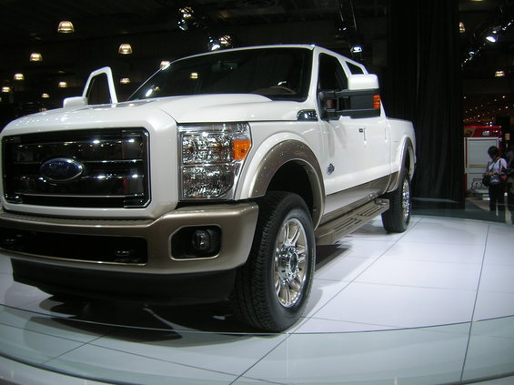 White and brown Ford F-Series truck with doors open on display floor
