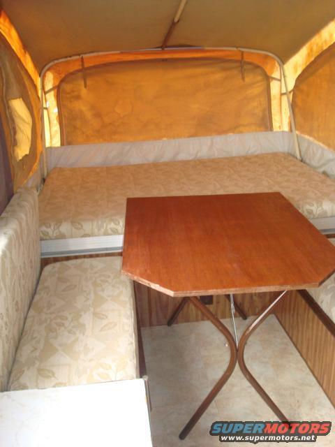 Interior of pop-up camper with dinette and sleeping area