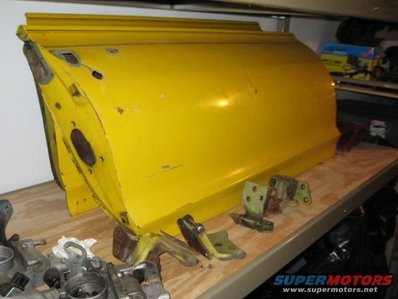 Yellow car door with detached hinges on a shelf