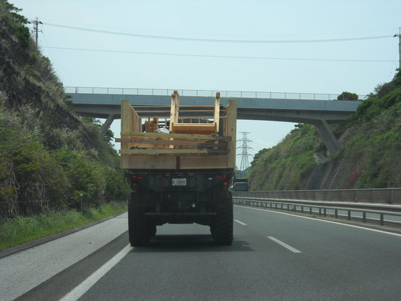 Rear view of military truck carrying wooden cargo on highway