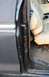 1979 Ford Bronco - Close-up of the interior door frame and seat, showing damage to the black paintwork.